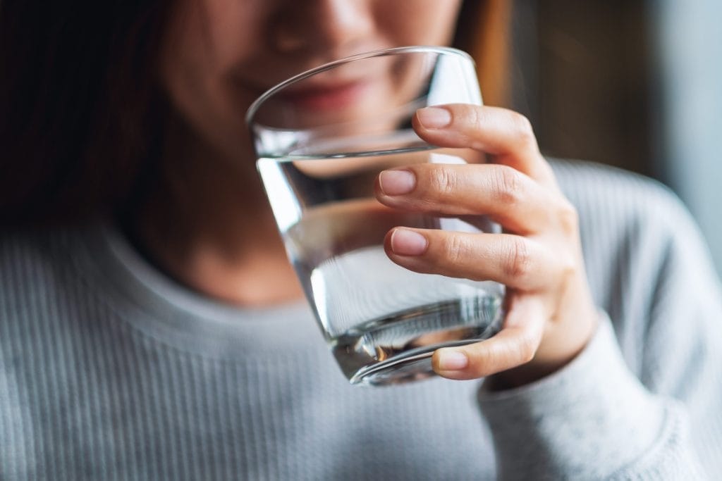 Person Holding a Glass of Filtered Water