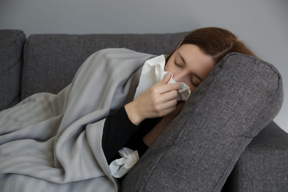 Woman Lying on Couch with Tissue