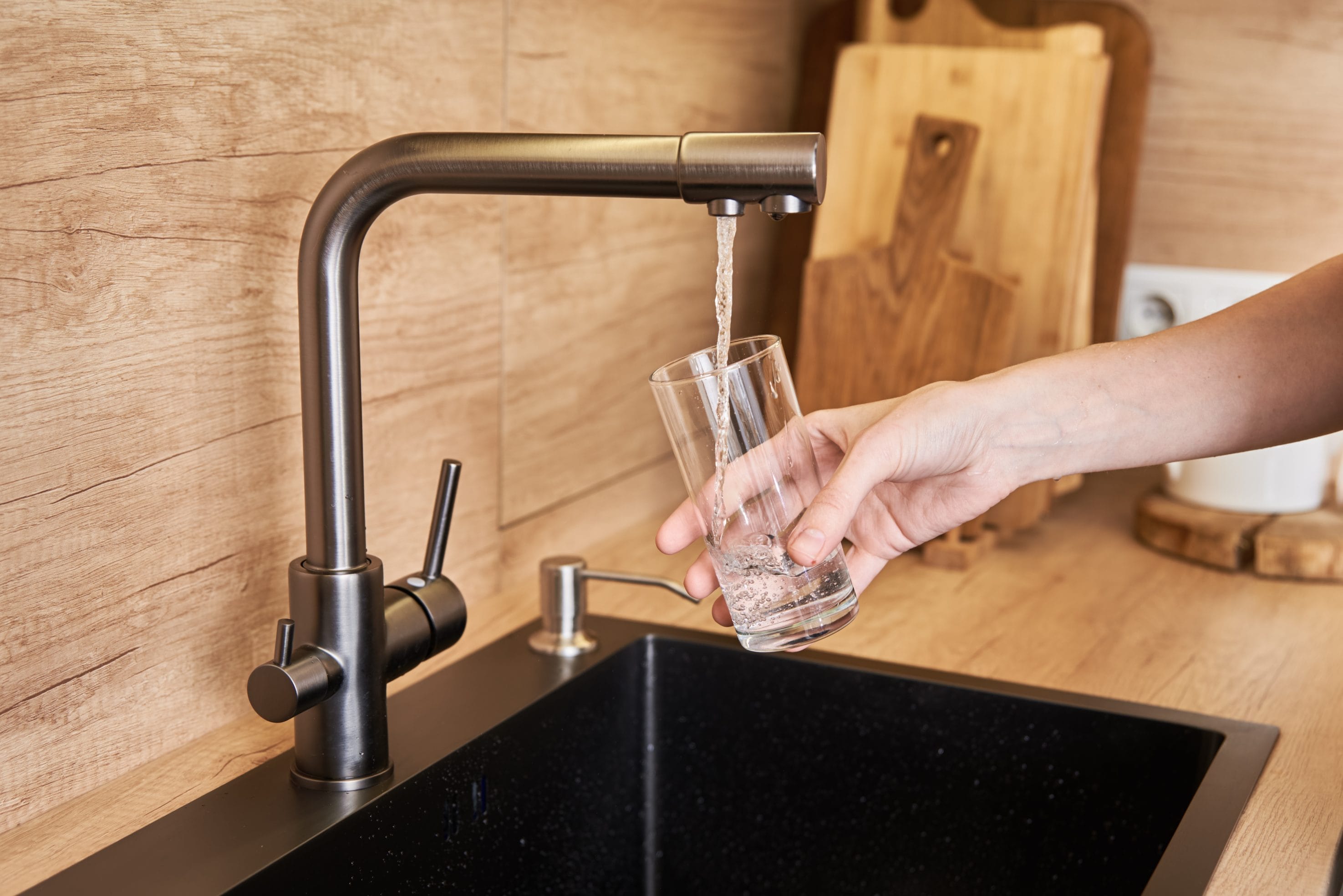 Woman pouring drinking water free from mercury into a glass
